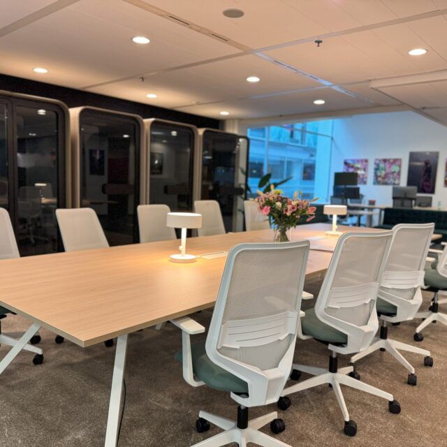 Moderne kantoorruimte met samenwerkplek en stile cabines