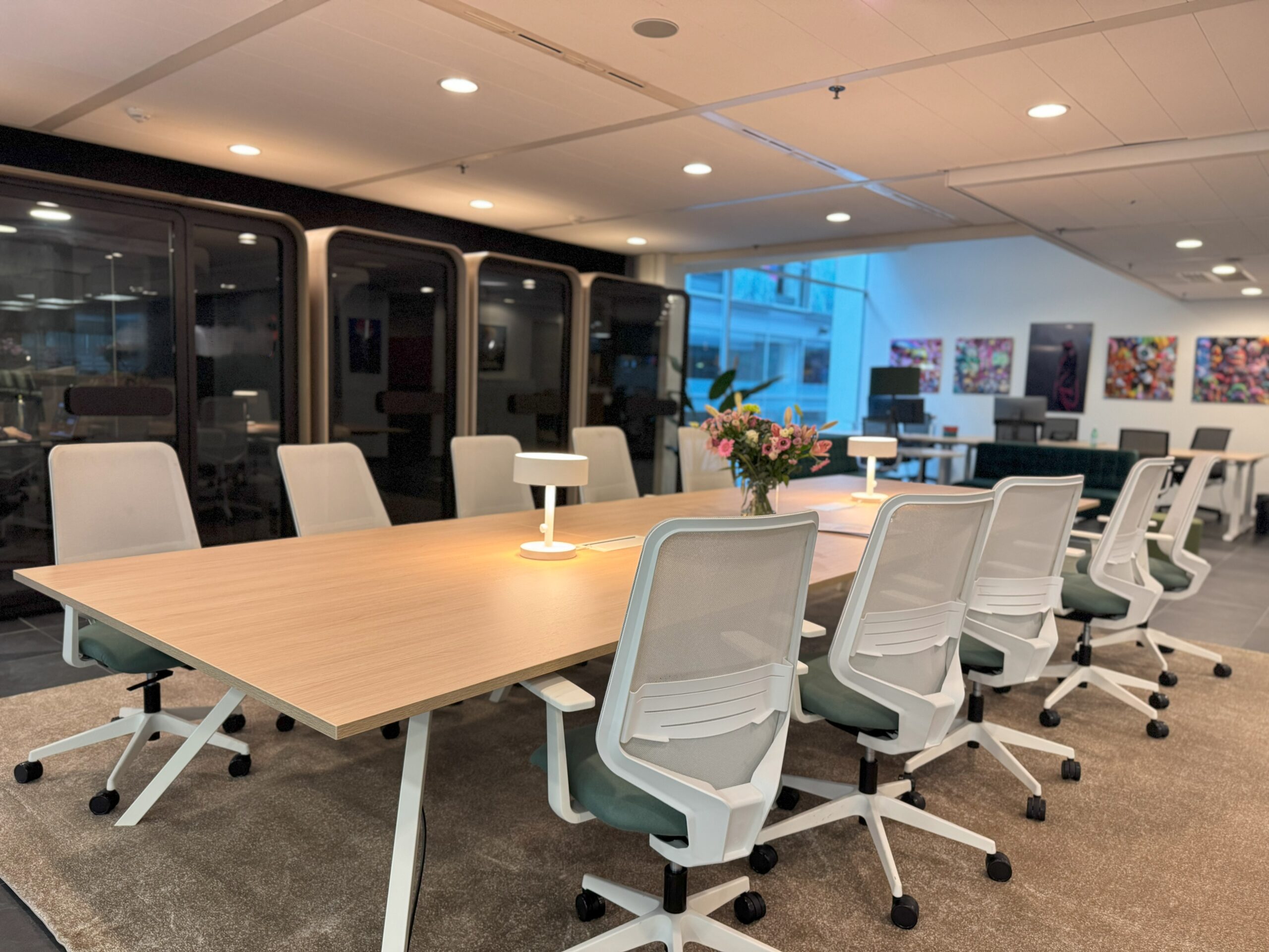 Moderne kantoorruimte met samenwerkplek en stile cabines